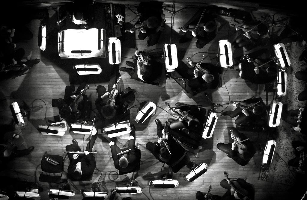 Attendees floating in zero gravity while experiencing a cosmic musical performance with planets and stars