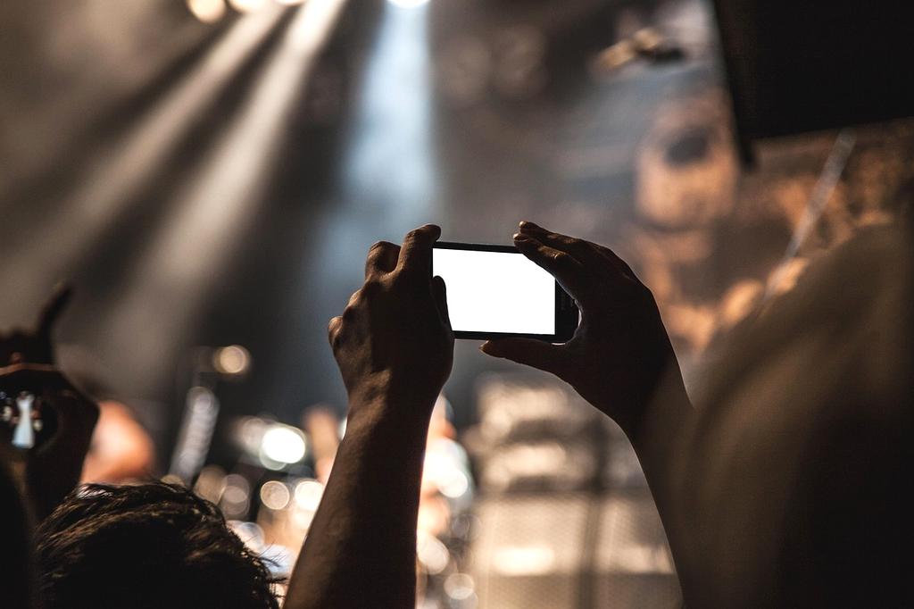 Outdoor concert stage with huge audience and vibrant sunset